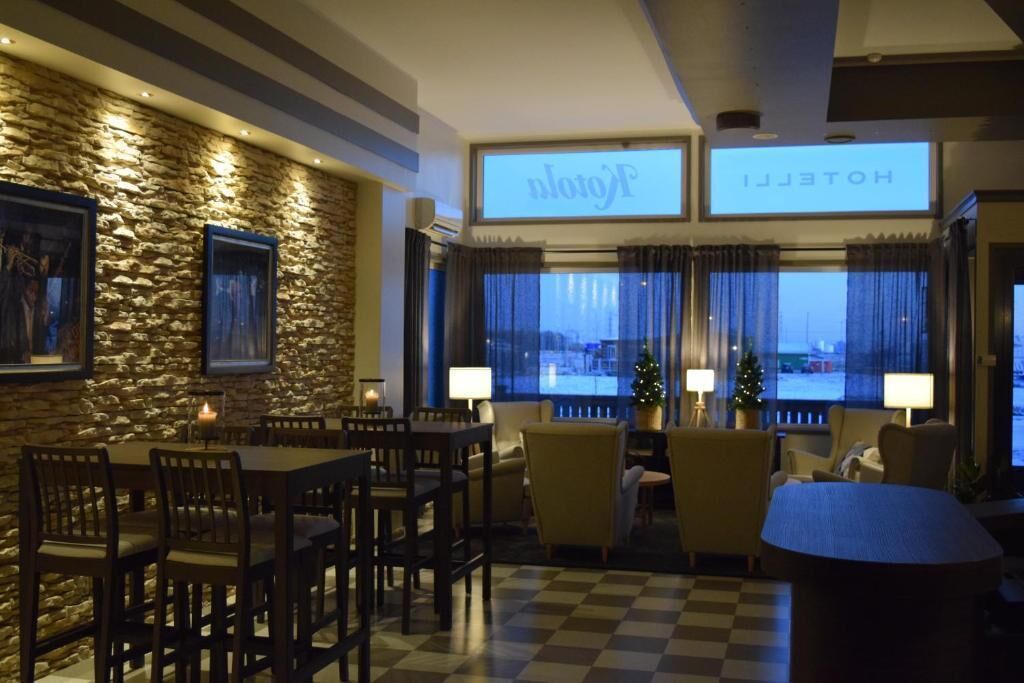 A hotel lobby with a stone wall, a checkered floor, and a Christmas tree.