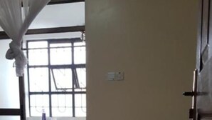 Un dormitorio con cama, ventana, cubo de basura y armario.