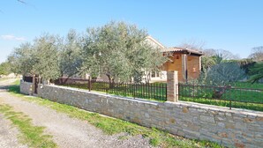 A stone wall with a gravel path leading to a rustic building with a tiled roof. - Holiday house on peaceful location in the suburb of Pula (Pula)
