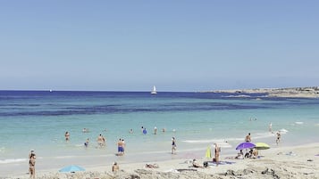 On the beach, white sand, sun loungers, beach umbrellas