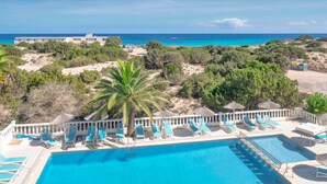 A pool area with lounge chairs and a view of the ocean. - Roquetes Rooms - Formentera Break (Formentera)