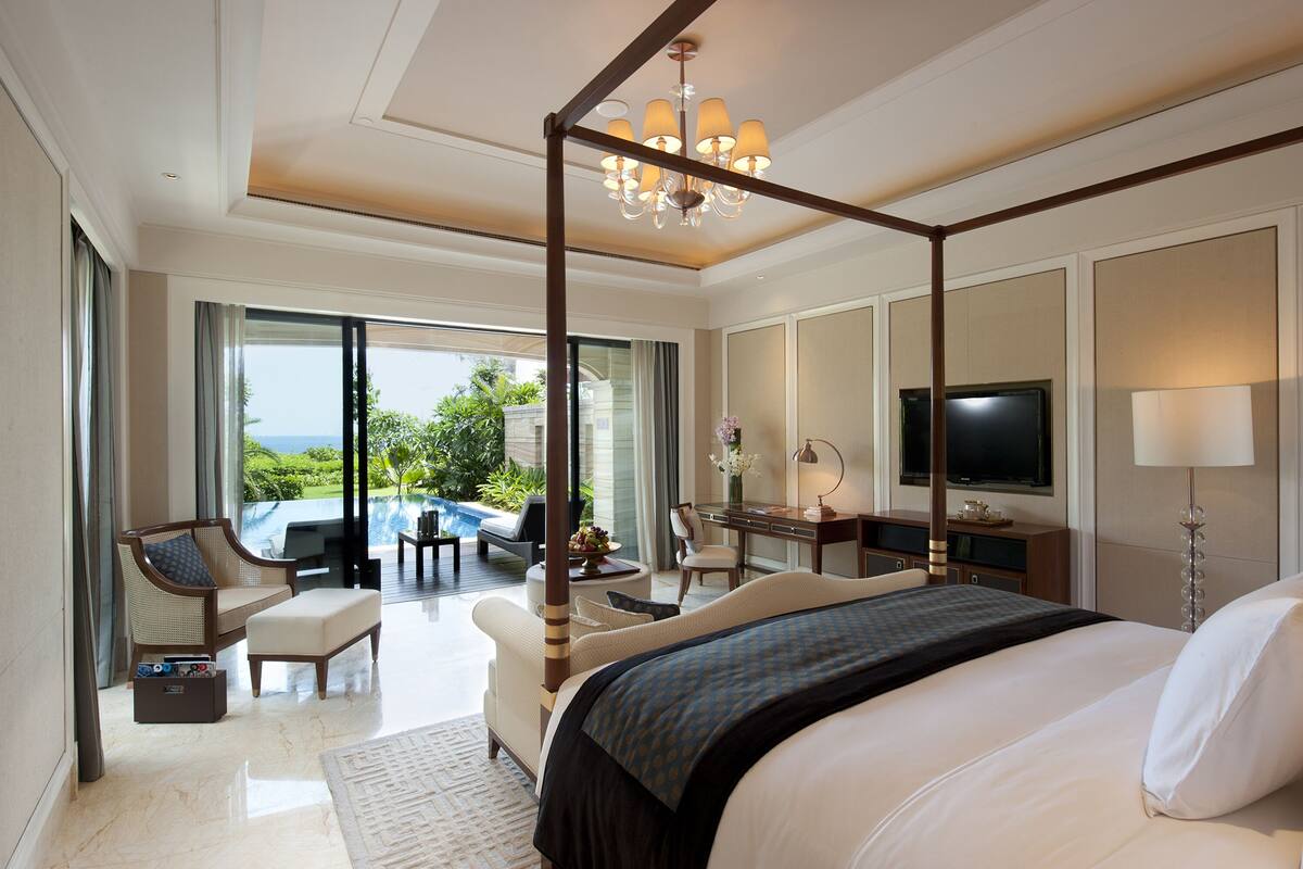 Une chambre spacieuse avec un grand lit, un bureau, une chaise et un téléviseur.