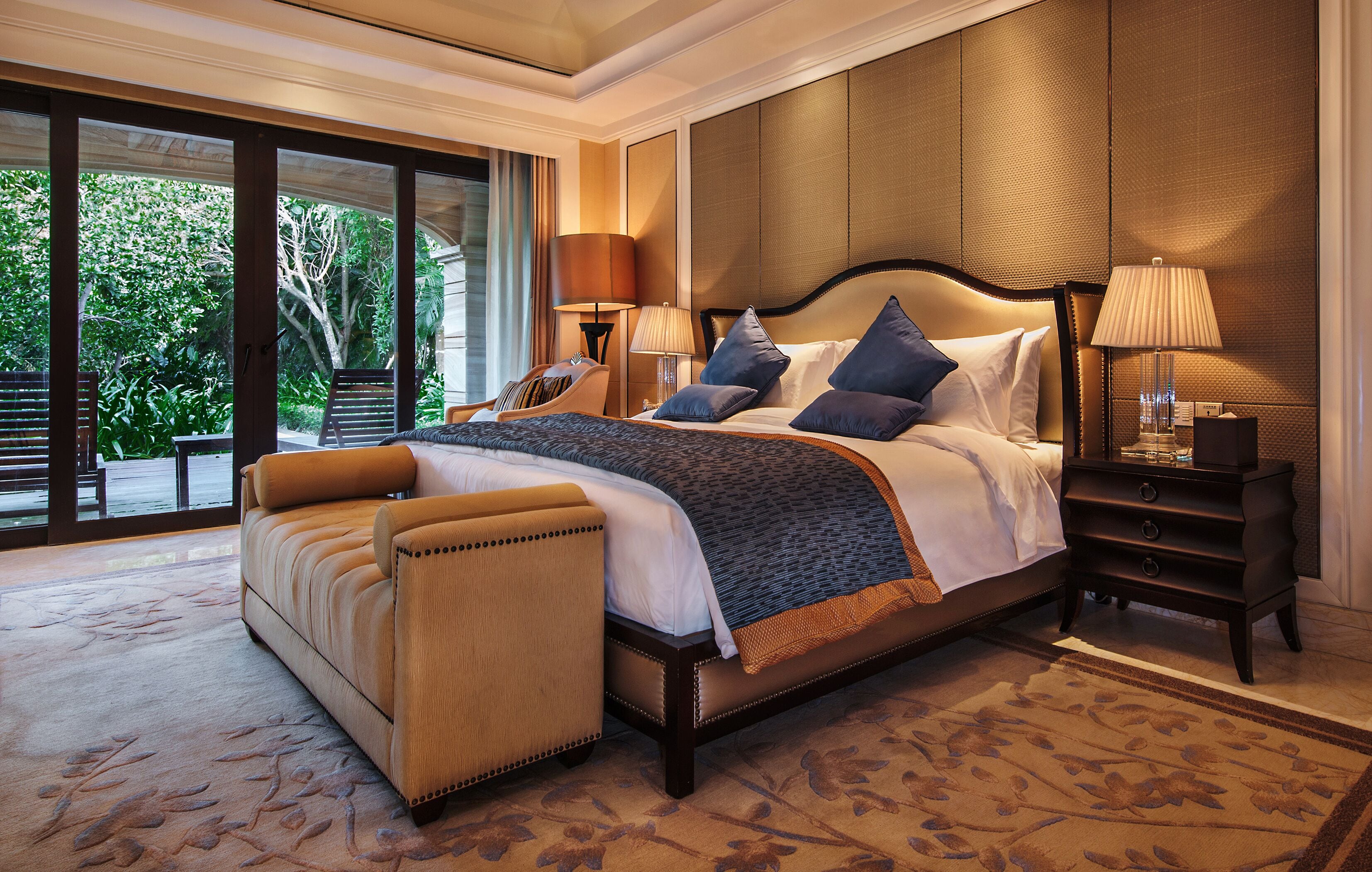 Un dormitorio espacioso con una cama grande, un área de descanso y vistas al exterior.