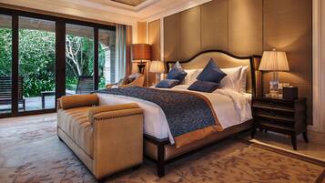 Un dormitorio espacioso con una cama grande, un área de descanso y vistas al exterior.