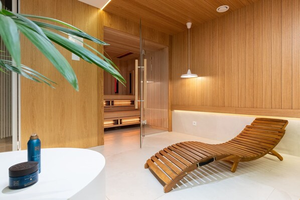Une salle de spa moderne avec un fauteuil en bois, un comptoir d’accueil blanc et une grande plante en pot.