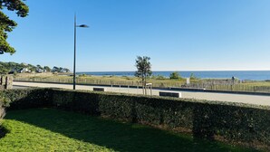 A coastal view with a paved walkway, a street lamp, and a hedge. - HORTENSIAS - Holiday apartment with sea view, facing the beach - T6 (Carnac)