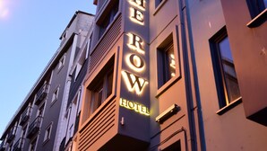 A hotel named "The Row" with a modern facade, multiple balconies, and a prominent illuminated sign. - The Row Taksim Hotel (Istanbul)