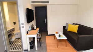 A compact living space with a kitchenette, a dining area, and a seating area with a sofa and coffee table. - The Row Taksim Hotel (Istanbul)