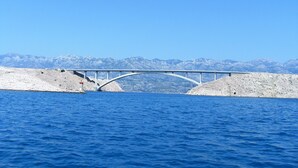 Un pont enjambant une étendue d’eau, avec une chaîne de montagnes en arrière-plan.