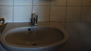 Une salle de bain avec un miroir rond, un lavabo et des toilettes.