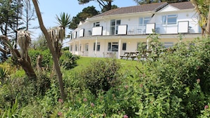 Ein zweistöckiges Gebäude mit Balkon und Terrassenbereich.