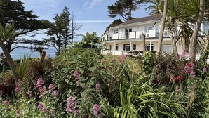 A two-story building with balconies overlooking a garden and a view of the sea. - Cosy Apartment with Private Balcony & Fantastic Sea Views (Torpoint)