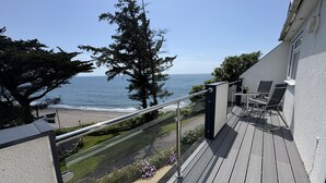 A balcony with a view of the ocean, a chair, and a small table. - Cosy Apartment with Private Balcony & Fantastic Sea Views (Torpoint)