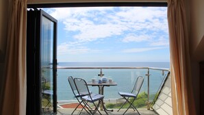 A balcony with a table and chairs, overlooking a body of water. - Seaside Duplex Apartment with Amazing Sea Views (Torpoint)