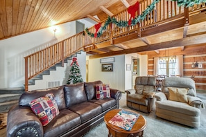 Cozy living room with a high ceiling, leather sofa, and wooden coffee table.