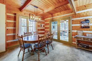 Cozy cabin interior with a large dining table and chandelier.