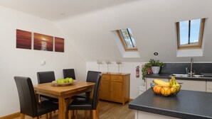 Una cucina moderna con un lucernario, un tavolo da pranzo in legno e sedie.