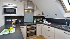 Una cucina moderna con forno a microonde, forno e un lucernario.