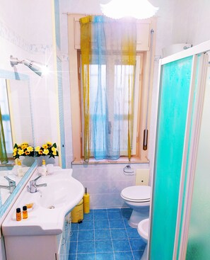 A bathroom with a white sink, a toilet, and a shower area. - Altea Royale (Naples)
