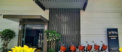 Entrada de un hotel con un cartel que dice 'Let's Stay in Panorama Suites'.