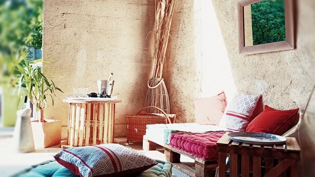 Ein gemütliches Zimmer im rustikalen Stil mit Bett, kleinem Tisch und hängender Pflanze.