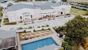 Ein großes Gebäude mit Pool, Sitzgelegenheiten im Freien und einem gepflegten Rasen.