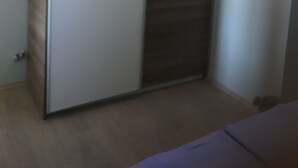 A room with a wardrobe featuring a combination of light and dark panels. - Cozy apartment on the ground floor with a small terrace (Privlaka)