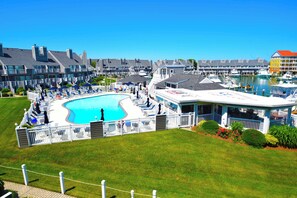 A resort with a large swimming pool, multiple guest rooms, and a marina.