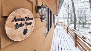 A wooden sign reading "Acorn Shores Lake House" on a building's exterior wall.