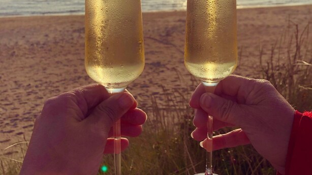Two hands holding champagne glasses with a beach and ocean in the background. - Beach cottage No. 7 SKREA STRAND (Hallands län)