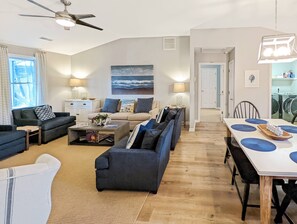 Uma sala de estar moderna com um conjunto de sofá, uma mesa de centro e um espaço de jantar com mesa e cadeiras.