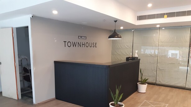 A reception desk with a sign reading "ALANA TOWNHOUSE".