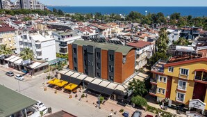 Un hotel dal design moderno, con un segno 'DN' ben visibile sulla facciata, situato in una zona costiera urbana e con vista sul mare.