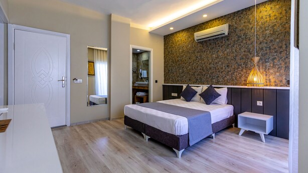 Camera da letto moderna con un letto grande, comodini, uno specchio e un armadio a muro.