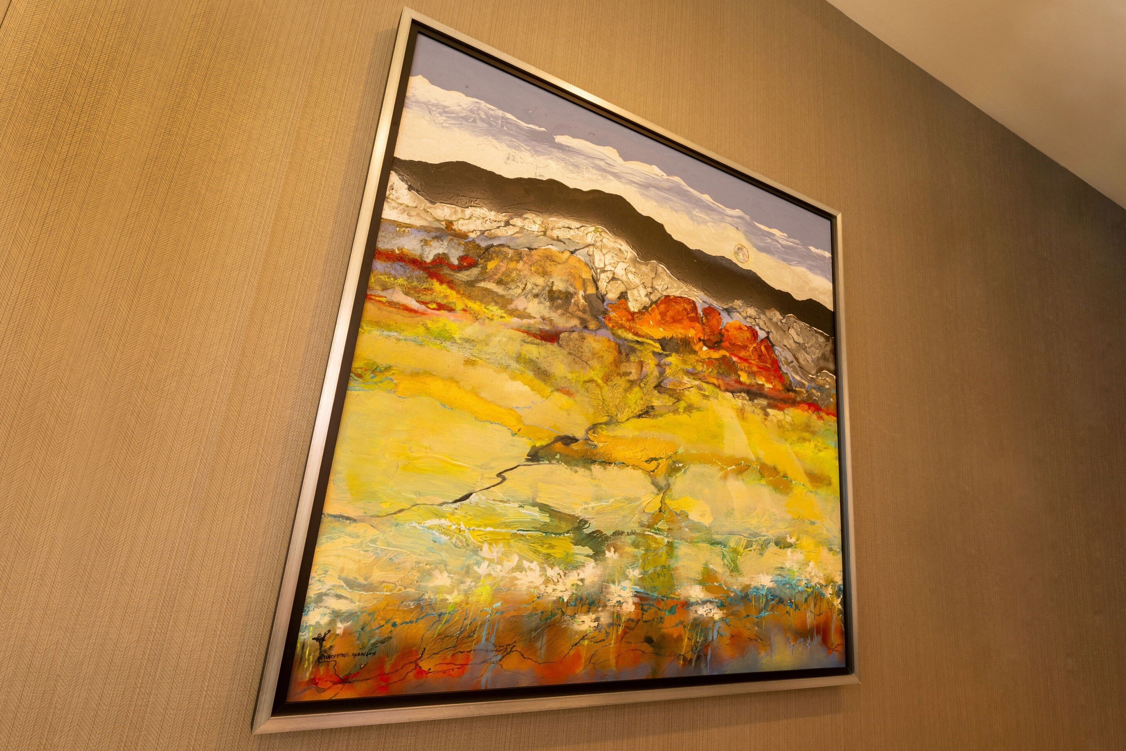 A framed abstract painting on a wall.