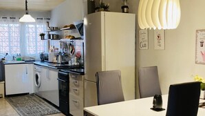 Een compacte keuken met een eethoek, inclusief een tafel, stoelen en een koelkast.