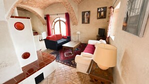 A compact living space with a sofa, a coffee table, a TV, and a lamp. - L'Ombria – Charming Villa with a Private Pool (Belgodère)