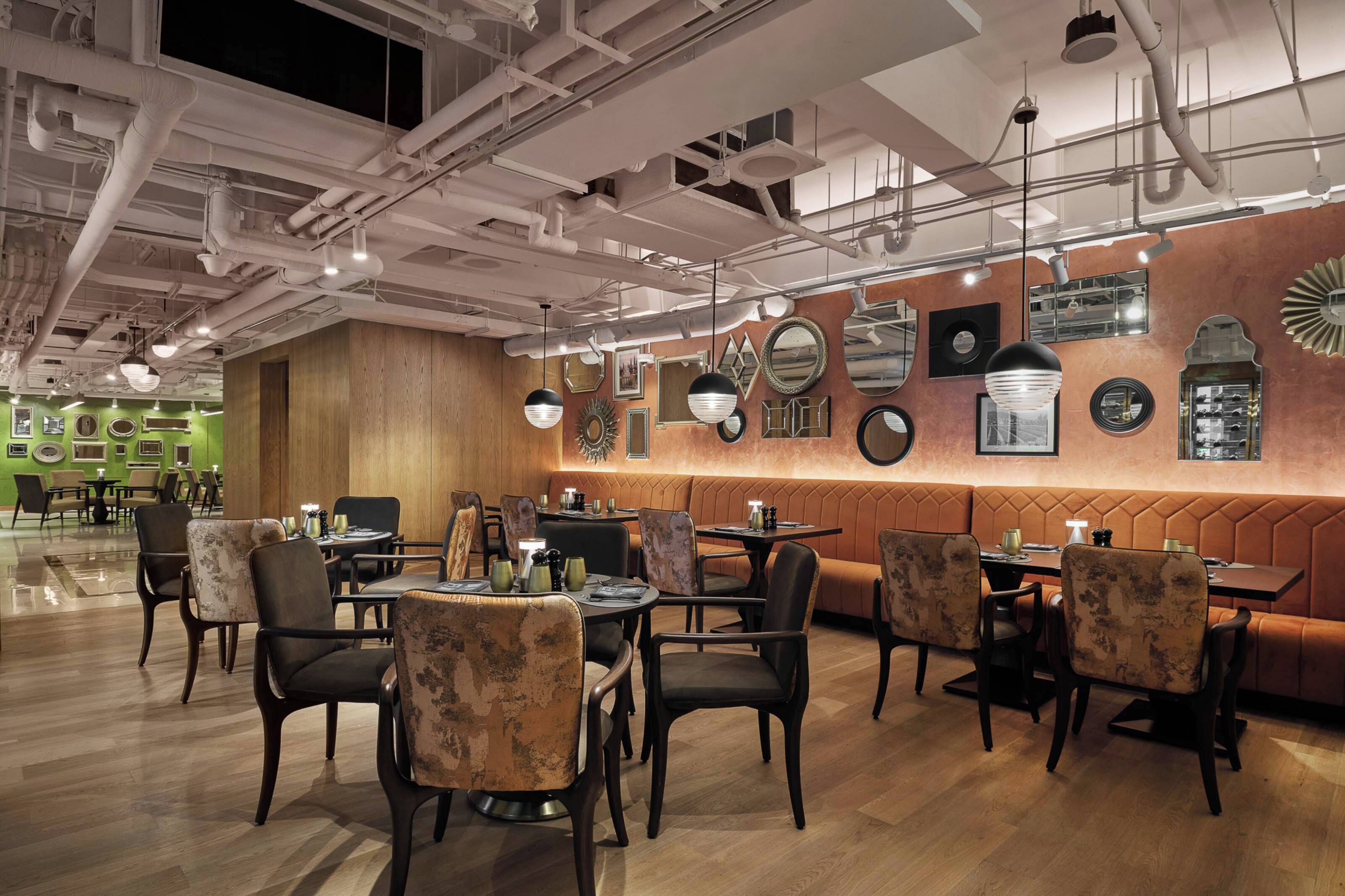 A restaurant interior with booths, tables, and hanging pendant lights.