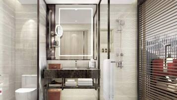 A modern bathroom with a large mirror, a shower, a toilet, and a vanity with towels.
