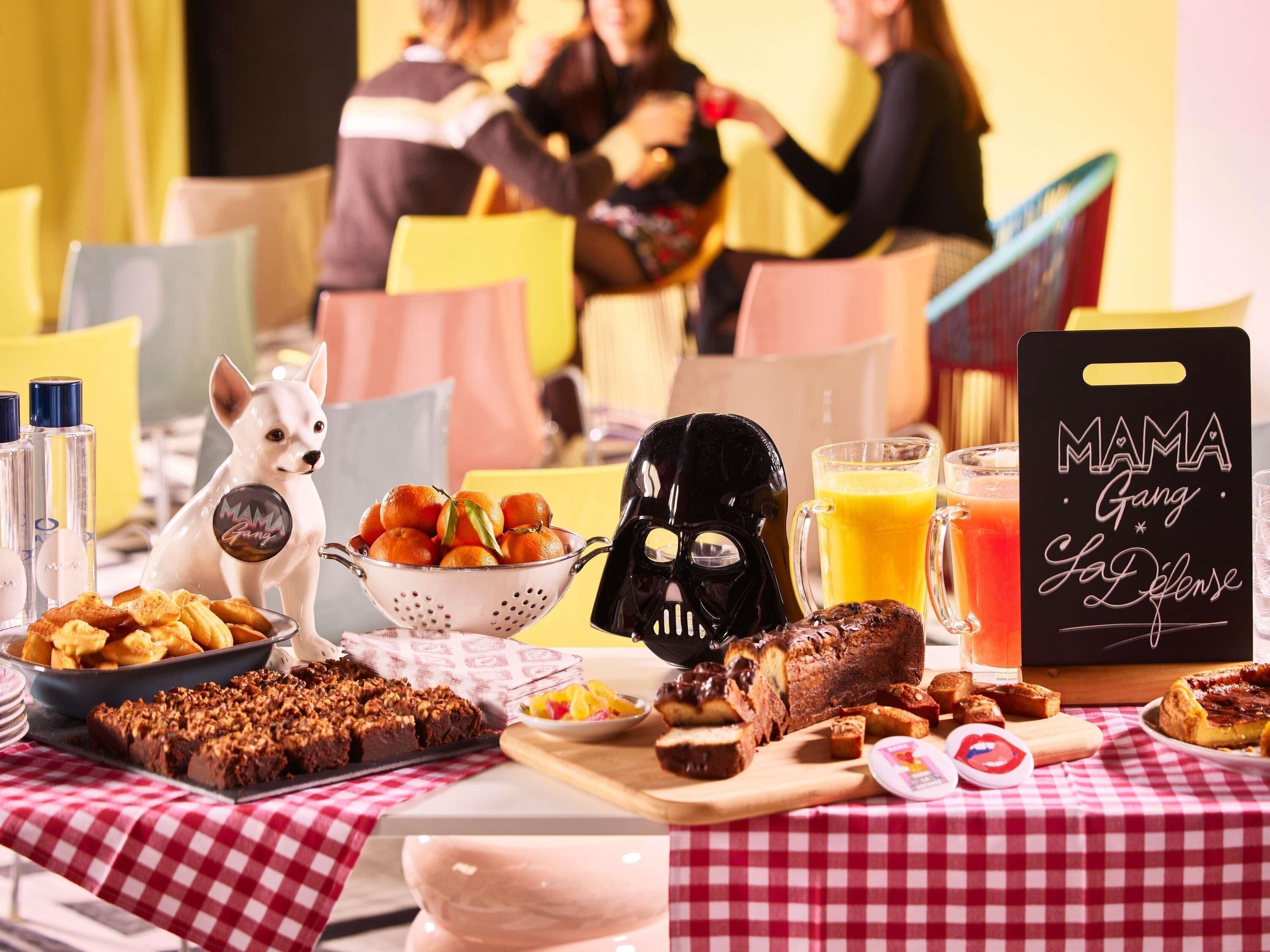 A table with food items, a Darth Vader figurine, and a sign reading 'MAMA Gang La Lêjêse'.