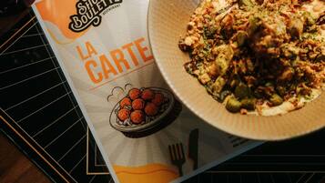 A menu titled 'La Carte' from Show Boulotte Restaurant, featuring a dish with vegetables and meat.