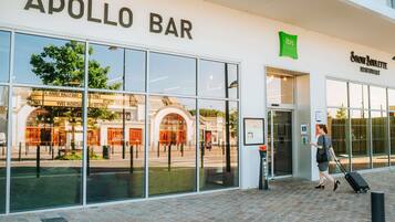 Un edifici amb una façana on es llegeix 'APOLLO BAR' i un cartell d'ibis Styles sobre l'entrada.