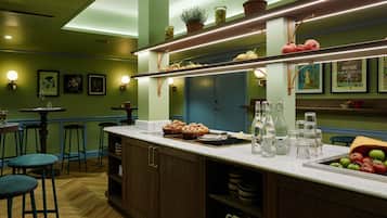 A restaurant with a bar area, wooden bar stools, and a counter with food and drinks.