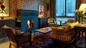 Una sala de estar acogedora con chimenea, papel tapiz estampado y asientos cómodos.