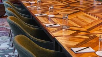 A conference table with chairs, water glasses, and notepads.