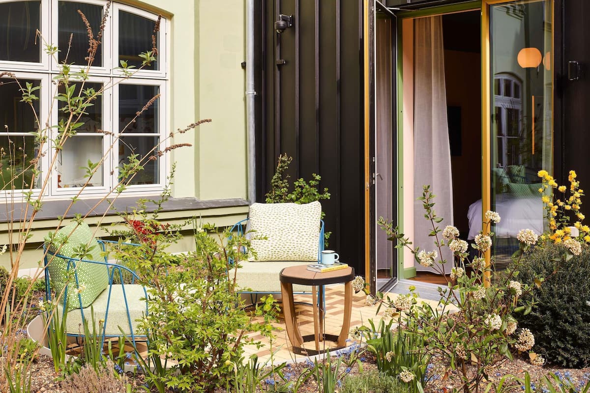 A cozy outdoor seating area with a chair, a small table, and a potted plant.