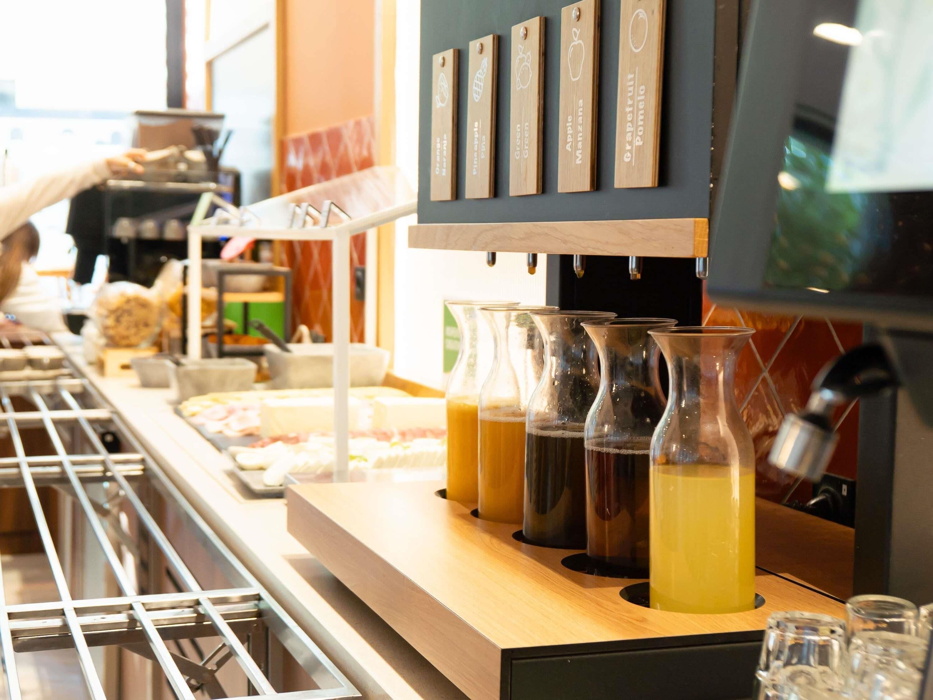 Een koffiebar met een assortiment dranken en een menubord met drankjes.