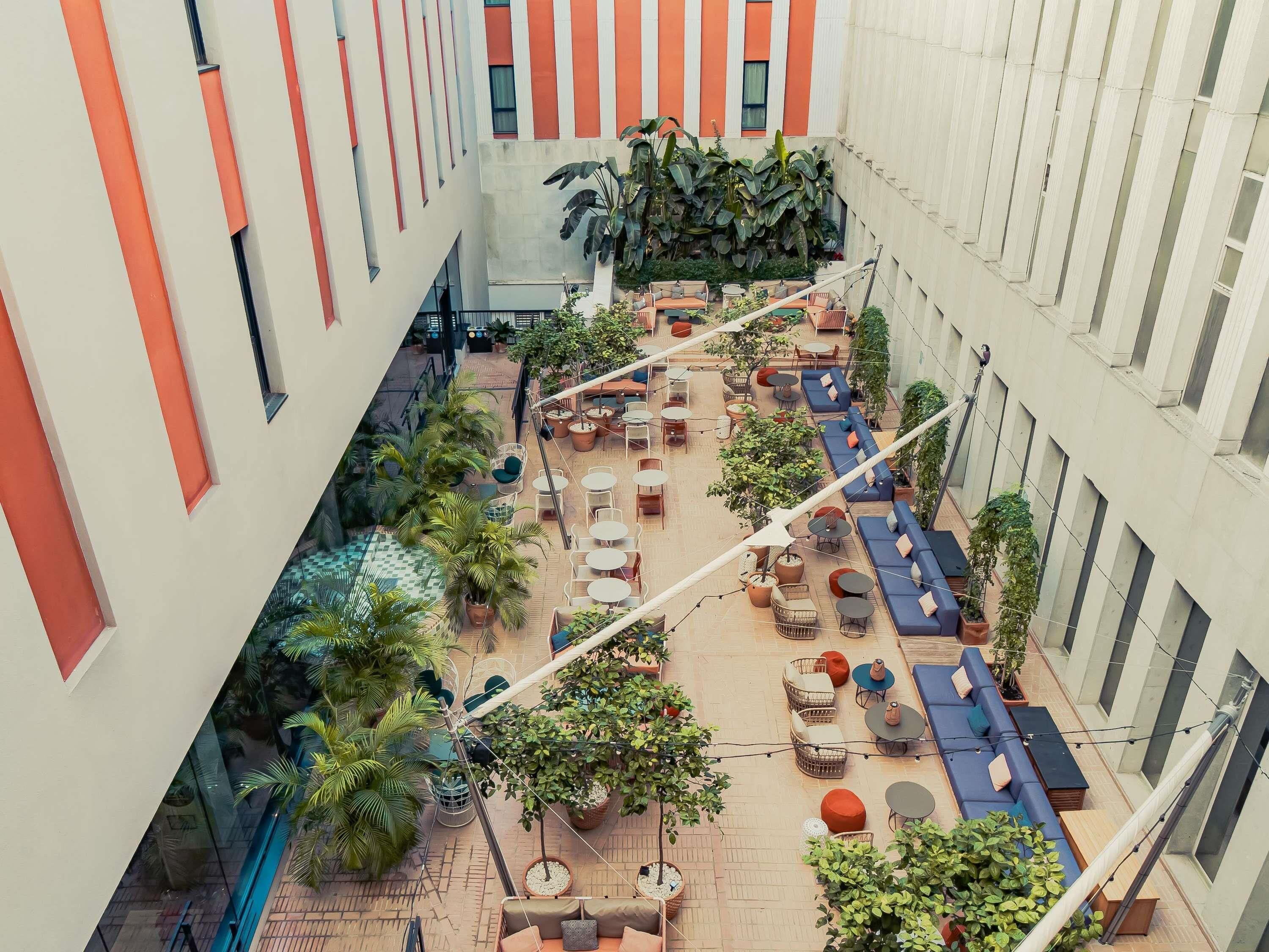 Een binnentuin met zitgedeeltes, potplanten en een uitzicht op het exterieur van het gebouw.
