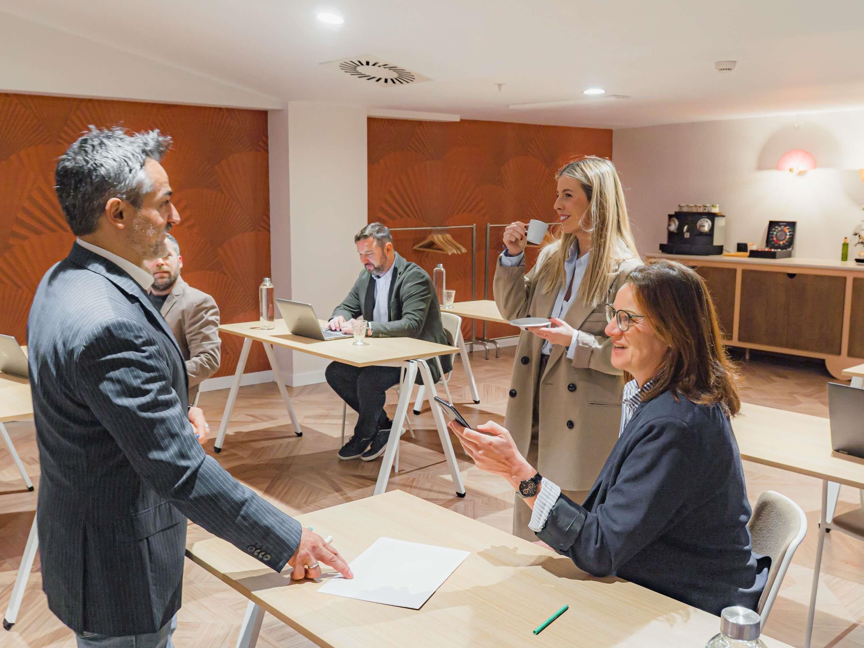 A conference room with a long table, chairs, and a whiteboard.