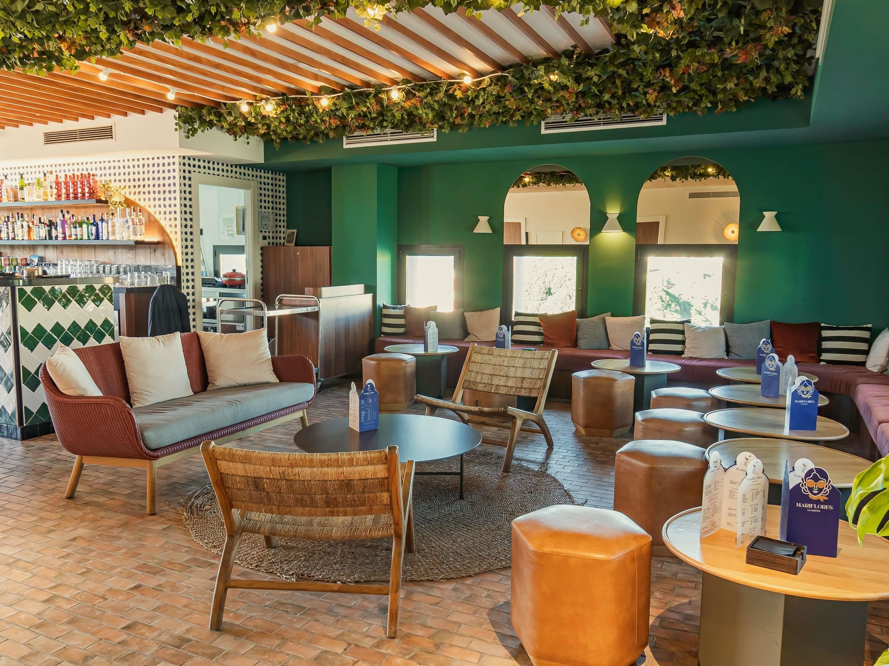 A cozy lounge area with seating, tables, and a bar.